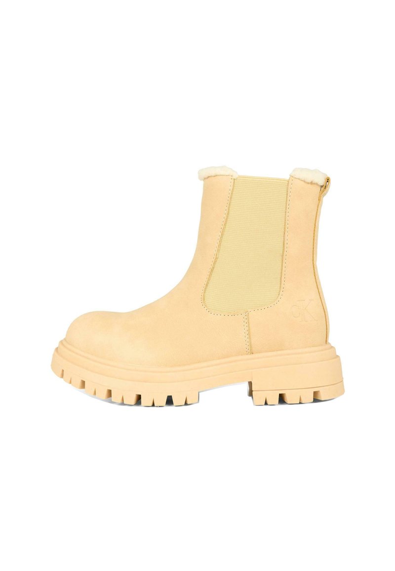 Stivaletti in suede beige con pannelli laterali elastici, bordo in pelliccia al colletto e suole in gomma spessa caratterizzate da un battistrada evidente.