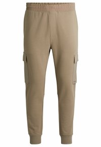 Beige Cargo-Jogginghosen mit elastischem Bund, schmal zulaufenden Beinen, Seitentaschen und gerippten Bündchen. Glattes Material mit einem schlichten Design.