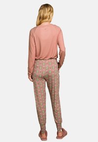 Langemouwen roze top met gemusterde joggingbroek in roze, groen en witte tinten. Zachte stof met elastische manchetten en tailleband.