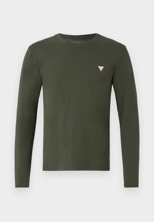 Chemise à manches longues vert olive en coton doux. Elle possède un col rond et un petit logo triangulaire blanc et orange sur la poitrine gauche.