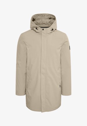 Chaqueta beige resistente al agua con capucha, que cuenta con una cremallera frontal, cierre a presión y dos bolsillos laterales; textura de tela suave.