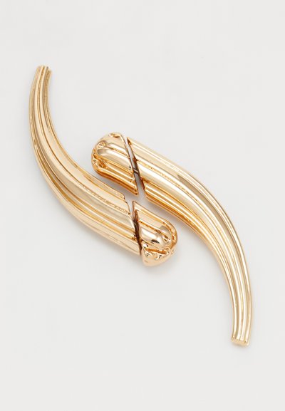 Accesoriu pentru păr cu ton de aur, compus din două piese curbate, alungite, cu un finisaj lustruit și striții decorative, conectate în centru.