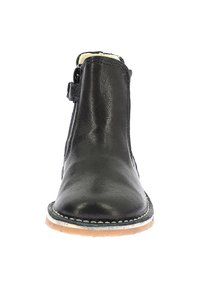 Stivale alla caviglia in pelle nera con punta rotonda, zip laterale e cuciture bianche sulla suola. Design minimalista e dalla texture ruvida.