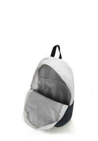 Zaino con un'esterno bianco e navy, dotato di un interno grigio. Include un'apertura con zip e una tasca interna per l'organizzazione.