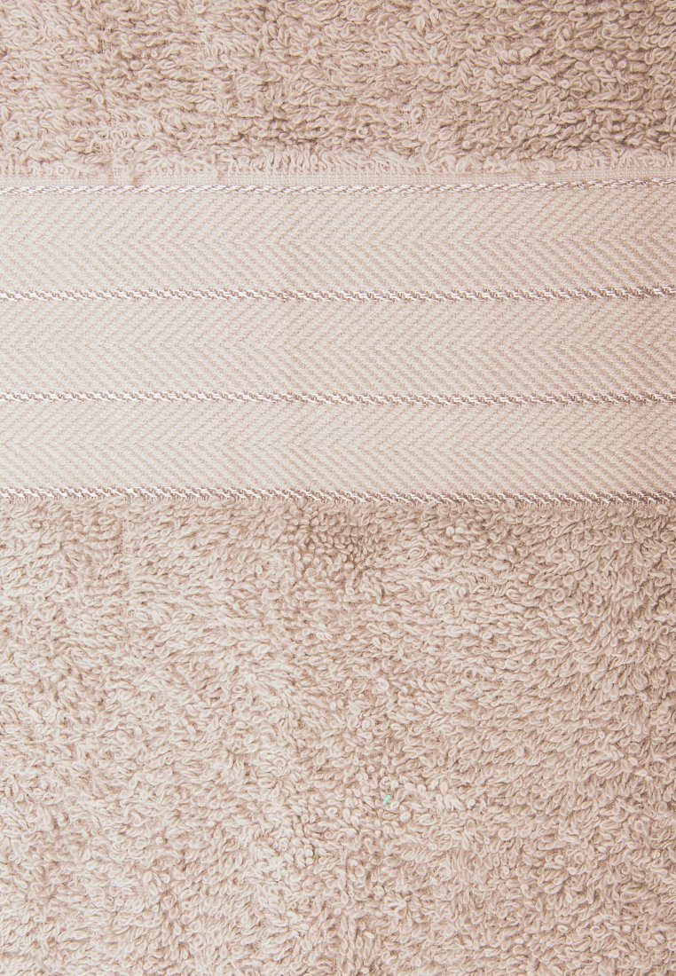 Helle beige Badetuch aus strukturierter, geschleifter Baumwolle, mit einem glatten Fischgrätenmuster-Band nahe der Oberseite und kontrastierenden Nähten.