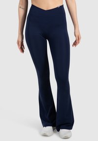 Granatowe legginsy typu dzwony z wysokim stanem, wykonane z elastycznego materiału. Gładka faktura i minimalistyczny design, idealne na odzież sportową.