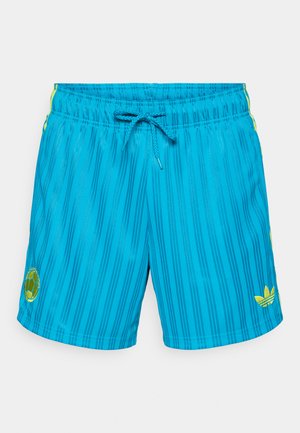 Bañador corto a rayas azules con cintura de cordón, con detalles en amarillo y un parche con logo en el lado izquierdo. Material ligero y suave.