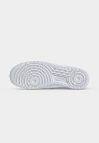 Λευκή σόλα αθλητικού παπουτσιού Nike με κυκλικά μοτίβα πέλματος και το λογότυπο Nike στο κέντρο.