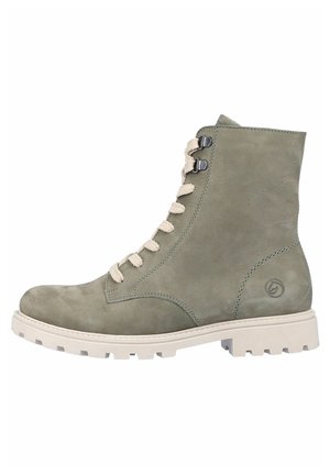 Bottine en daim vert avec des lacets beige, à bout rond et semelle blanche robuste. Elle présente des œillets en métal et un détail de logo sur le côté.
