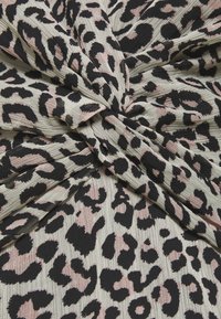 Tissu à imprimé léopard avec un mélange de taches noires et roses sur un fond crème texturé, présentant un design froncé.