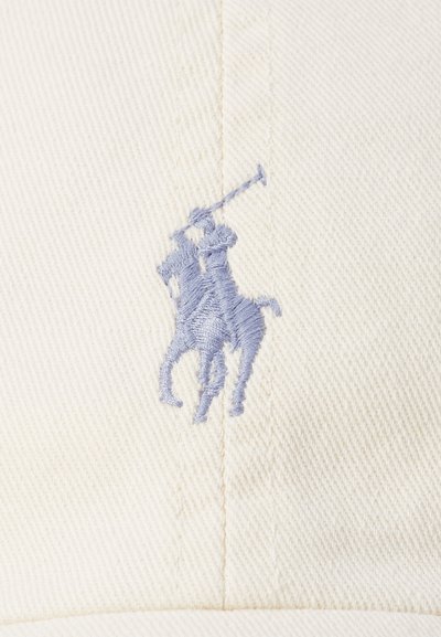 Căciulă albă din bumbac, cu un logo brodat de culoare albastru deschis reprezentând un jucător de polo pe un cal, având detalii vizibile de cusătură și un material texturat.