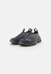 Fekete és szürke, slip-on stílusú cipők, hálós felsőrésszel, texturált felülettel, hátsó húzófülekkel és strapabíró gumitalppal a tapadás érdekében.