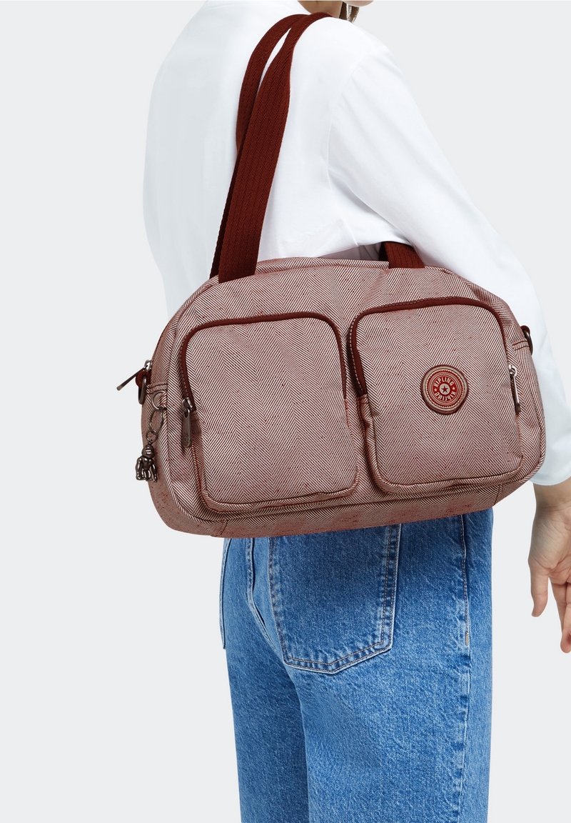 Rød skuldertaske med fiskebensmønster, to frontlommer, rundt logo og stærke brune stropper, lavet af slidstærkt stof.