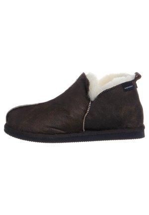 Dunkelbraune Leder-Ankle-Slipper mit weißem Fleece-Futter und schwarzer Sohle, mit einem Etikett an der Seite und einer Zuglasche an der Ferse.