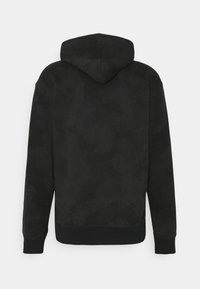 Black hoodie made of soft fabric with a smooth texture, featuring a rounded hood and ribbed cuffs and hem. No visible branding or patterns.