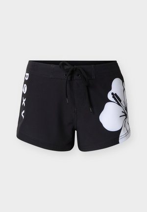 Schwarze Boardshorts mit schwarzem Kordelzug am Bund, weißer Hibiskusblüte am rechten Bein und "ROXY"-Schriftzug vertikal am linken Bein.
