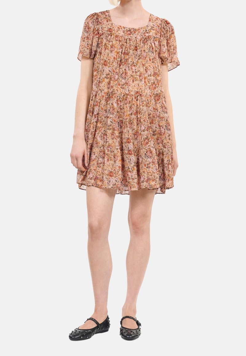 Vestido corto floral en tonos de naranja y rosa, de tela ligera con mangas cortas abullonadas y cintura fruncida, complementado con zapatos planos negros.