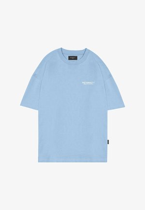 T-shirt oversize bleu clair en coton avec un col rond et des manches courtes. Présente du texte imprimé blanc sur la poitrine et une étiquette sur le côté.