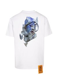 Weißes Baumwoll-T-Shirt mit einem fragmentierten Grafikdesign eines Gesichts in Blau- und Grautönen auf der Rückseite, sowie einem Marken-Logo in Orange an der Seite.