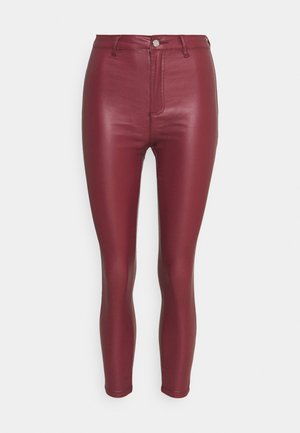 Pantalon slim en simili cuir bordeaux taille haute, avec passants de ceinture, fermeture par bouton et zip à l'avant, présenté sur fond blanc.