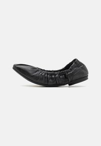 Bailarinas de cuero negro con punta afilada, diseño de borde fruncido y tacón bajo. La textura suave y el minimalismo en los detalles realzan la forma.