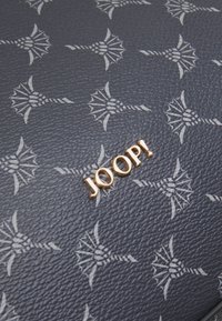 Lederbörse mit einer dunkelblauen strukturierten Oberfläche, geprägt mit einem floralen Muster und akzentuiert durch ein goldfarbenes "JOOP!"-Logo.