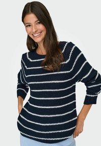 Pull en tricot bleu marine avec des rayures blanches horizontales, col rond et manches trois-quarts. Tissu doux avec une coupe décontractée.
