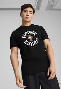 Sort bomulds t-shirt med "PORTUGAL" i hvid tekst og et centralt Portugal-våbenskjold, samt et lille rødt Puma-logo på kanten.
