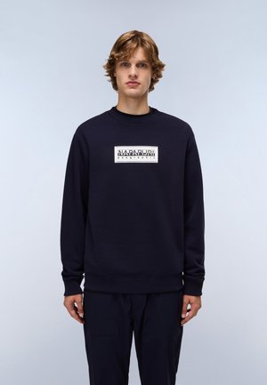 Navy sweatshirt in soft fabric with a crew neck, featuring a contrasting logo patch on the chest and ribbed cuffs and hem.