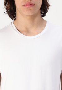 Hvid kortærmet t-shirt med rund hals, lavet af glat stof; minimal design uden mønstre eller accenter.