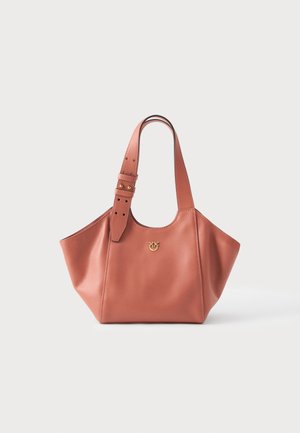Bolsa tote de couro rosa suave com alça larga ajustável e pequeno emblema dourado na frente, exibida sobre fundo branco liso.