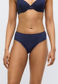 Μπλε βαμβακερά εσώρουχα με δαντελένιο περίβλημα σε κυματιστό σχέδιο, με μικρό φιόγκο στο μπροστινό μέρος. Μεσαία μέση και λεία υφή.