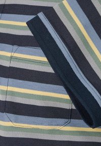 Pasiasty materiał z poziomymi liniami w kolorze granatowym, zielonym, żółtym i jasnoniebieskim. Zawiera małą kieszeń i żebrowany dekolt.