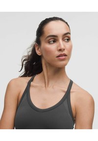 Sötét szürke sportos ujjatlan felső, kerek nyakkivágással és keskeny pántokkal, sima textúrával és finom varrási részletekkel.