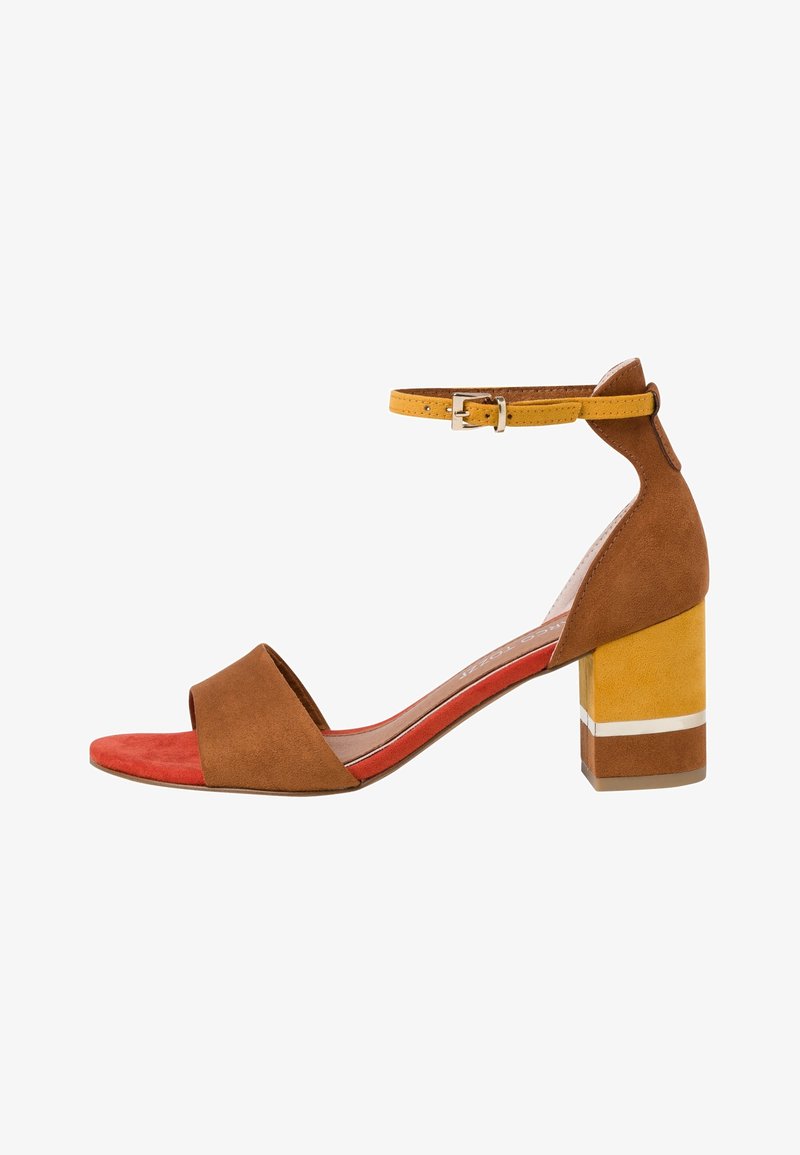 Sandale marron et jaune à talon bloc avec bride à la cheville et semelle intérieure rouge, vue de côté sur fond blanc.