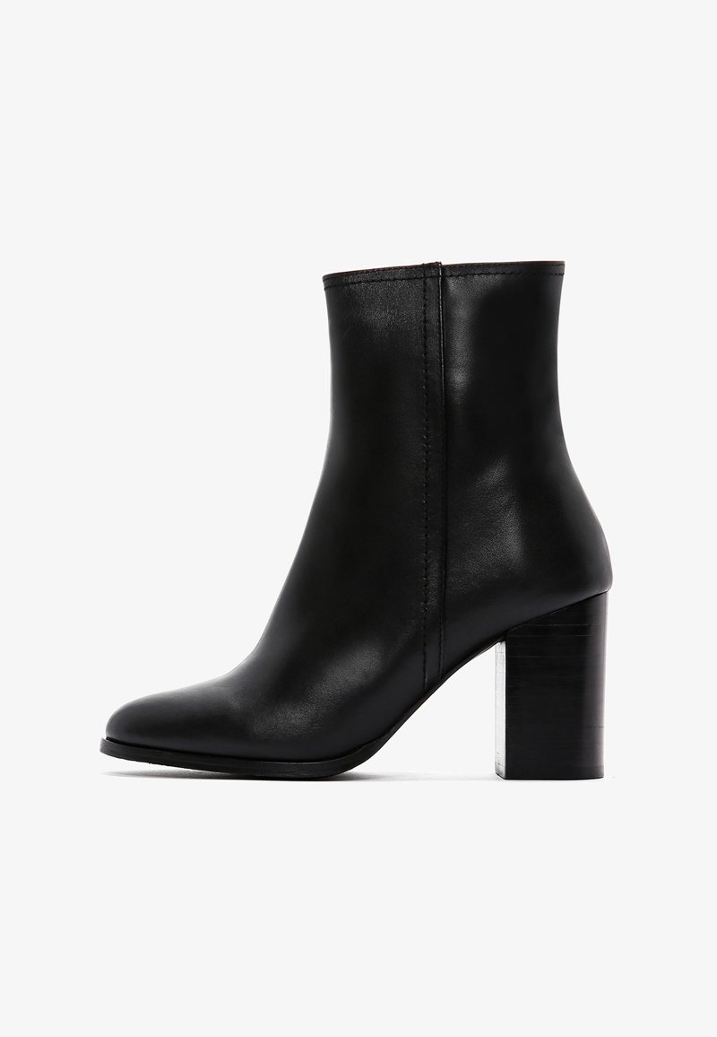 Bottine en cuir noir avec un bout pointu et un large talon carré. Présente une texture lisse et des détails de couture minimaux.