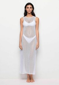 Weißes, langes, ärmelloses Kleid aus strukturiertem, offen gestricktem Material mit Karomuster, ausgestattet mit einem runden Halsausschnitt und seitlichen Öffnungen.