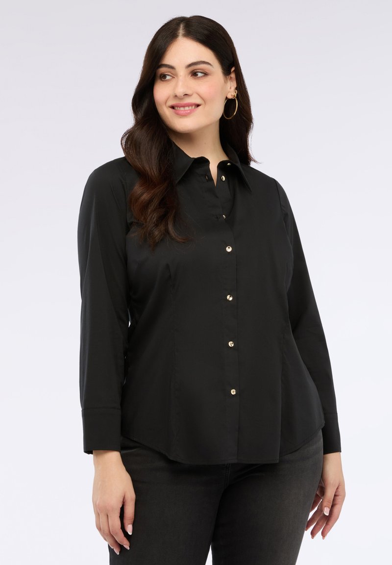 Camicia nera con colletto, maniche lunghe e orlo curvo. Presenta bottoni dorati e una trama di tessuto liscia.
