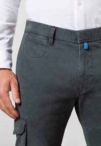 Tmavě šedé cargo kalhoty s hladkou texturou, s modrým akcentem na pasu, boční kapsou a klasickým střihem.