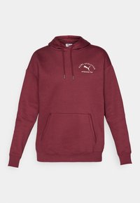 Burgunderfarget hettegenser laget av bomullsblanding, med kengurulomme, snøring i hetten og brodert logo på brystet. Glatt tekstur.