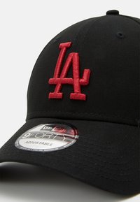 Boné ajustável preto com um destacado logótipo "LA" bordado em vermelho, tecido texturizado e um autocolante circular da marca na aba.