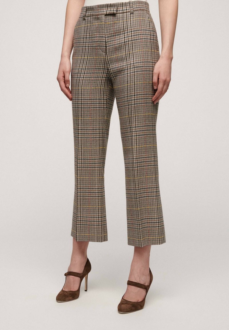 Rutig, högmidjad byxa i beige och brunt, med ett subtilt rutmönster med gula och röda accenter. Kort längd.