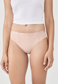 Jasnoróżowe figi bikini z gładkiego, elastycznego materiału. Posiadają miękki, błyszczący pasek w talii oraz bezszwowy krój dla większego komfortu.