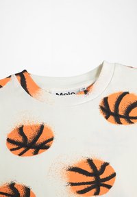 Bela majica s kapuco z oranžnimi košarkarskimi žogami in črnimi detajli. Tkanina izgleda mehka, s krožnim izrezom in rebrastimi robovi.