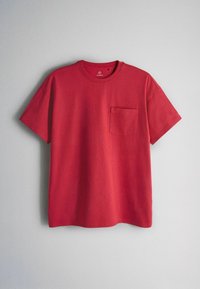 Rood katoenen T-shirt met korte mouwen, een borstzakje aan de linkerkant en een ronde hals, weergegeven tegen een effen lichtgrijze achtergrond.