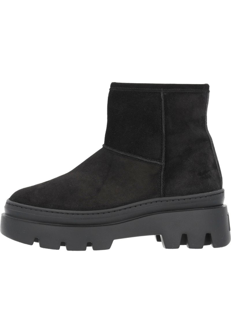 Bota corta de ante negro con una gruesa suela negra de plataforma, diseño minimalista, textura suave y sin herrajes ni patrones visibles.