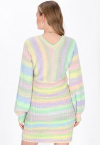 Pastellgestreiftes Strickkleid mit V-Ausschnitt, langen Ärmeln, gerippter Taille und weichem Material in den Farbtönen Grün, Pink und Lavendel.