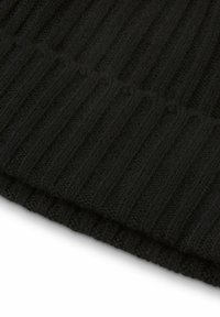 Tessuto a maglia nero con coste verticali e una consistenza morbida, che mostra un bordo piegato per un tocco di dettaglio in più.