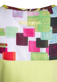 Helles grünes Hemd mit einem mehrfarbigen rechteckigen Muster im oberen Bereich, versehen mit einem goldenen "Desigual"-Logo. Glatte Stofftextur.