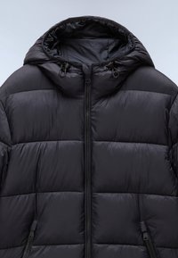 Czarna pikowana kurtka z kapturem, z zamkiem błyskawicznym z przodu i dwoma bocznymi kieszeniami. Gładka, błyszcząca tekstura z przeszywanymi segmentami.